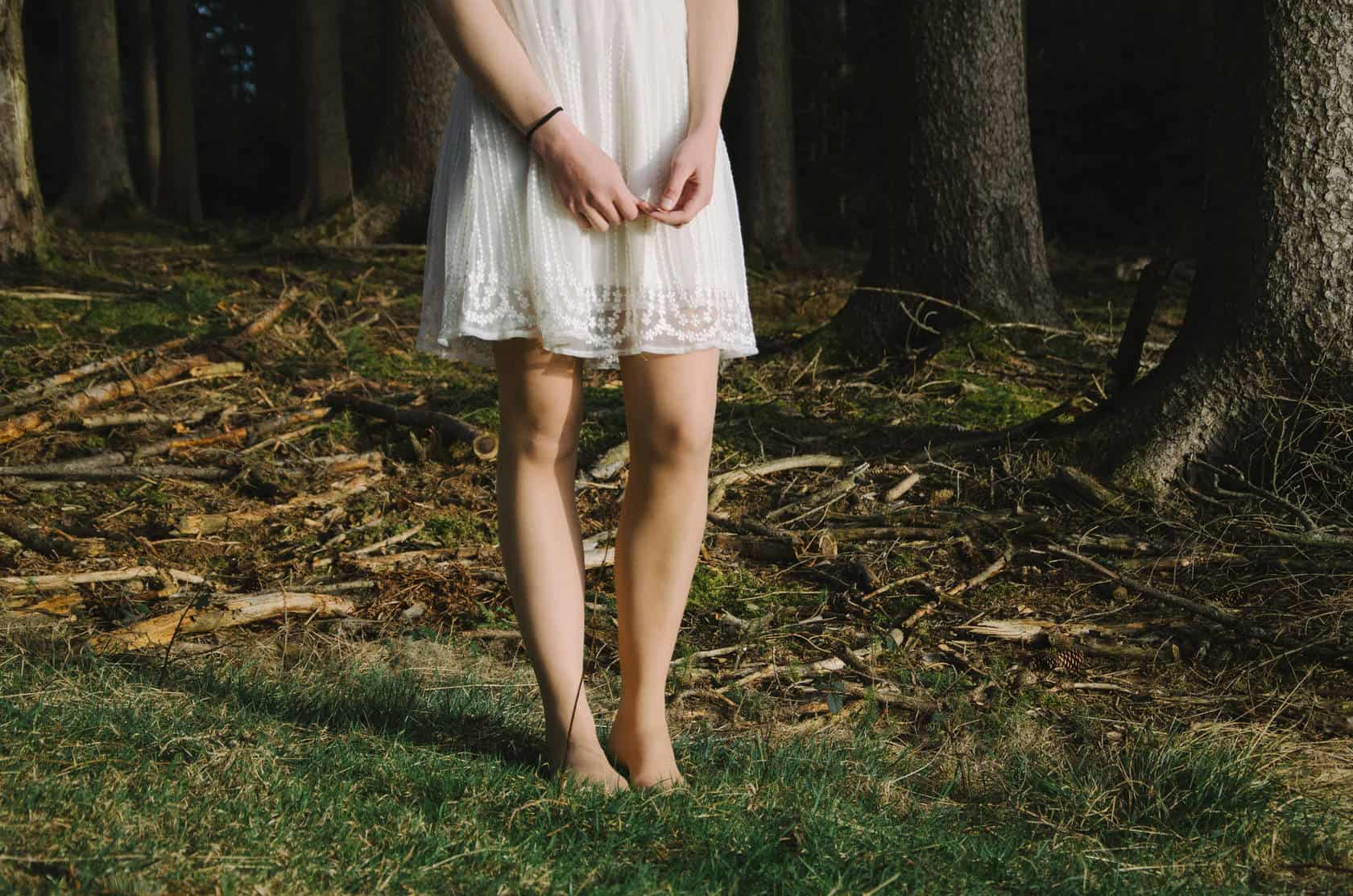 Top Chinese Science and Tech Official Urges Priority on Research Person standing barefoot in a forest clearing wearing a white dress.